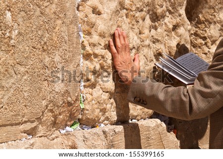 The praying with a book in his hand leaning against the Wailing Wall Royalty-Free Stock Photo #155399165