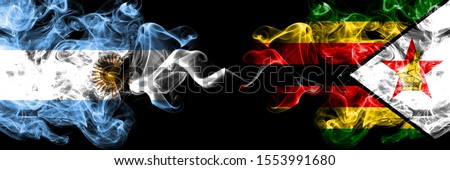 Argentina vs Zimbabwe, Zimbabwean smoky mystic fire flags placed side by side. Thick colored silky abstract smoke flags concept
