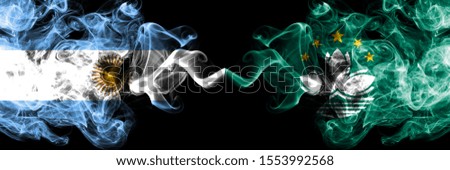 Argentina vs Macau, China smoky mystic fire flags placed side by side. Thick colored silky abstract smoke flags concept