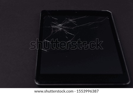 Image with broken display of a smartphone or tablet computer on black background.