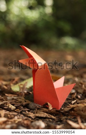 Big red origami fox in the forest