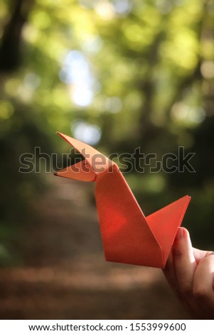 Big red origami fox in the forest