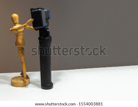Wooden dummy photographing with a camera on a dark background