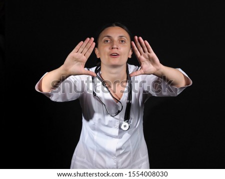 Female doctor shows hand gestures and poses on a black background
Female doctor in white coat shows different emotions posing on black background. Doctor template.
