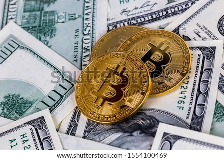 three bitcoin shiners on paper us dollar banknotes background