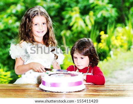 Litlle girl cuts her birthday cake