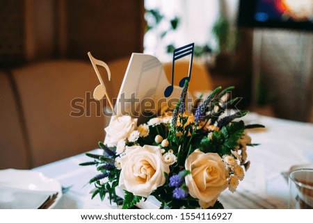 Table decorated with notes and flowers in a small piano
