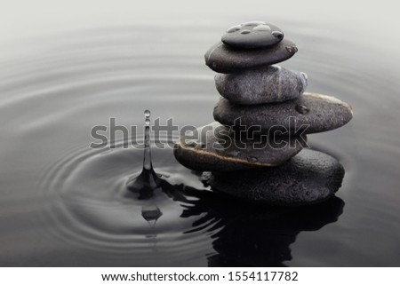 A zen black balance stones in a water with water drop