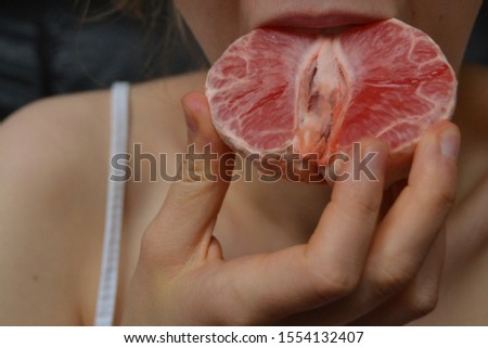 girl eating red grapefruit, a natural antioxidant. man eating tasty, fresh grapefruit. citrus fruit, a source of vitamin C. beautiful, simple photo with place for captions, words. prevention of colds.