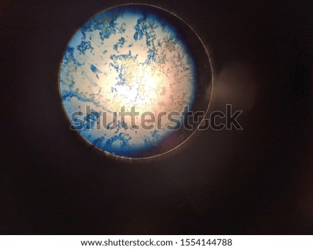 This is a picture of starch with blue dye on it underneath the microscope from my biology class. It looks do of a astronaut looking out a window and space to me.