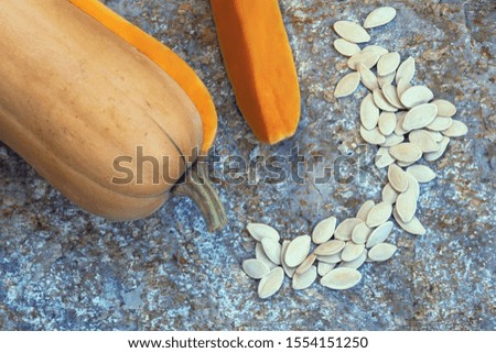 Pumpkin and pumpkin seeds on natural stone background 