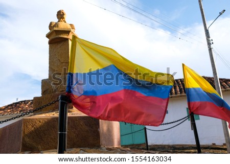 The statue of Simón Bolívar surrounded by colombian flags at Barichara, Colombia