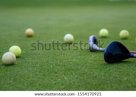 A golf player prepares the ball to be fired at the golf course