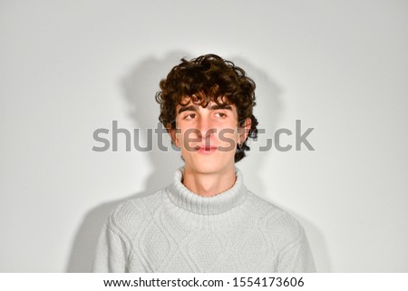 Portrait photography. handsome curly Italian teenager model boy posing for fashion shooting wearing winter turtleneck sweater