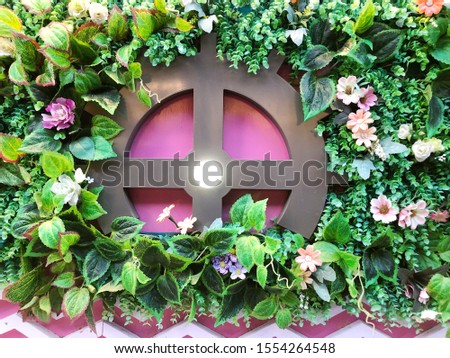 Decorative wooden frame with artificial leaves on the wall.