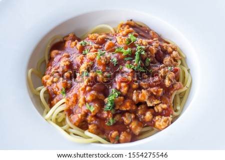 Close-up Spaghetti bolognese sauce with beef or pork,cheese,tomatoes and spices on white plate
