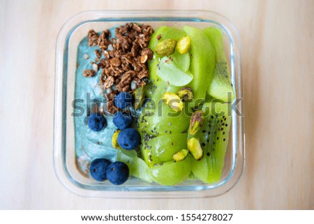 Spirulina smoothie bowl with green fruit and blueberry