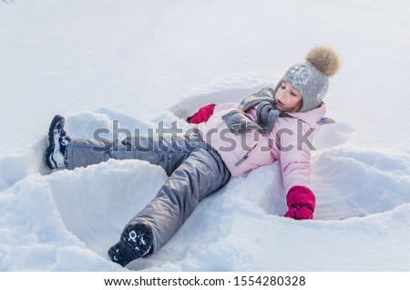 Cute girl plays with snow in winter. Winter Angel