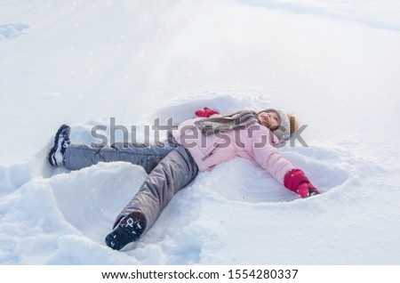 Cute girl plays with snow in winter. Winter Angel