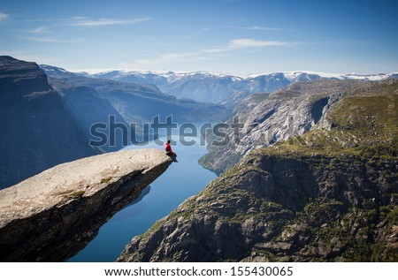 man sitting on trolltunga in norway  Royalty-Free Stock Photo #155430065