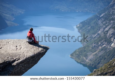 man sitting on trolltunga in norway  Royalty-Free Stock Photo #155430077