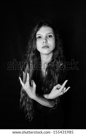Young woman with characteristic heavy metal hand gesture