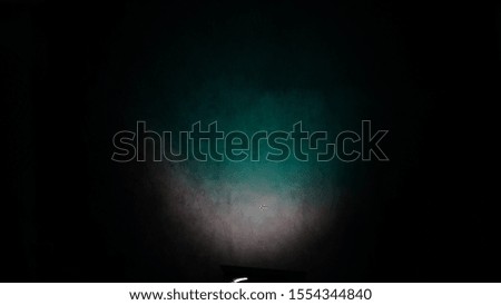 blue  green pulsing light on crumpled paper black background in Studio