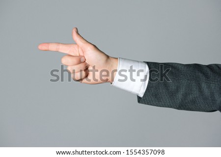 Businessman hand showing ahead by index finger isolated on gray background.