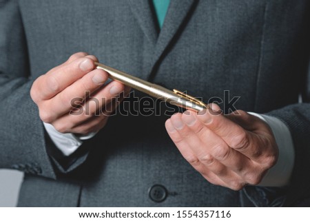 Ballpen in businessman hands close up. Royalty-Free Stock Photo #1554357116