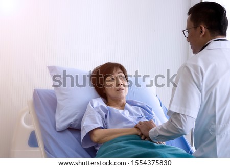 Elderly patient care concept; Asian doctor is taking care elderly patient woman in hospital.