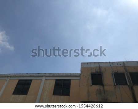 Perspective of old building and bright sky as backdrop, with summer glare light, free space for hour text design.