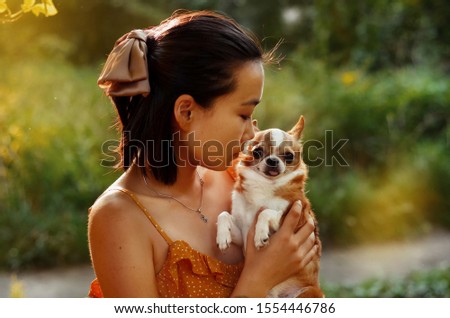 Fairy portrait of young girl and her little dog in the forest. Colorful picture of friendship. Chihuahua dog, place for text.