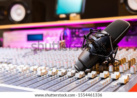 condenser microphone on audio mixing console in recording studio