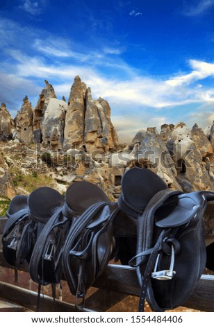 Open air museum, Goreme national park. Saddles equestrian on fence, blue sky clouds landscape Cappadocia, Turkey.