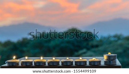 Lights of candles against blurred dramatic sky background
