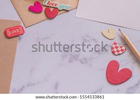 White paper card, pencil, envelope and lovely hearts with copy space. Realtionship concept of romance couple or lover or lovely family. Love photo frame and Valentine conceptual image.