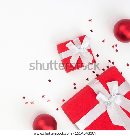 Corner frame from red Christmas gifts, balls, white background. Congratulation, Happy New Year concept. Top view, flat lay, copy space, square format