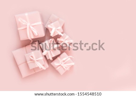 Christmas pink flat lay. Holiday boxes, fir branches on pink background. Christmas winter holiday congratulation invitation birthday wedding