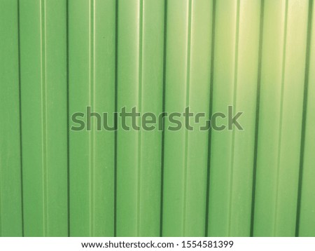 Green metal corrugated siding, modern finishing material for construction, background texture
