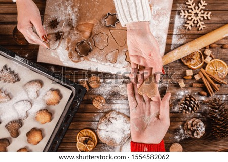 Christmas family traditions. Woman and man make christmas holiday homemade cookies. Top view.
