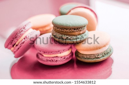 Pastry, bakery and branding concept - French macaroons on pastel pink background, parisian chic cafe dessert, sweet food and cake macaron for luxury confectionery brand, holiday backdrop design