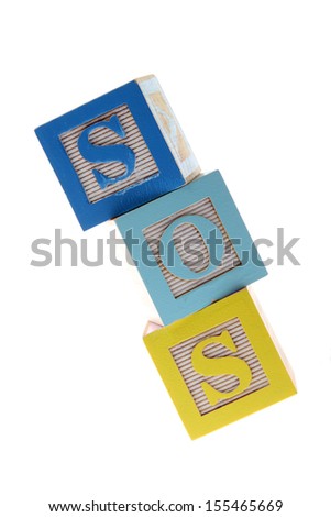 Assorted children's toy letter building blocks against a white background/Children's alphabet blocks spelling the words SOS