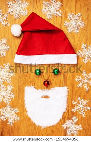 Santa Claus face on a wooden background created from Christmas decorations.