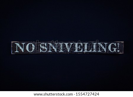 A "no sniveling sign" on a dark blue background