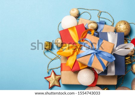 A stack of gifts and Christmas decorations on a blue background. Gift concept for a loved one, holiday, Christmas. Flat lay, top view