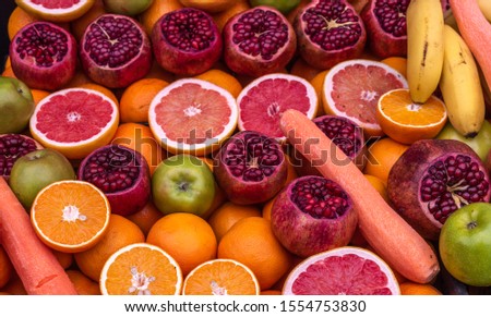 Fresh fruits (oranges, pomegranates, apples, bananas, carrots) for making juice.