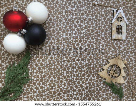 Christmas tree decorations little house, tree, the colored balls red, white, black, cypress branch on the white and brown geometric background, copyspace, a flat lay concept, holiday celebration decor