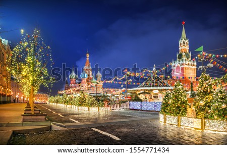 Christmas tree decorations on Red Square, domes of St. Basil’s Cathedral and Spasskaya Tower on a winter night
