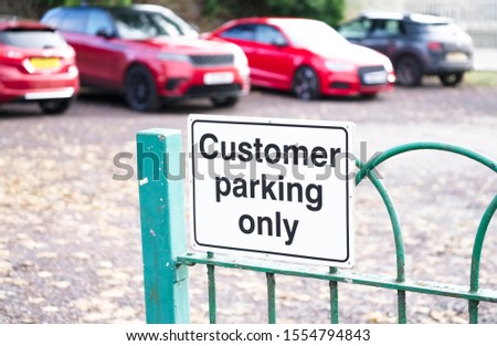 Customer parking only sign on car park staff gate at place of work