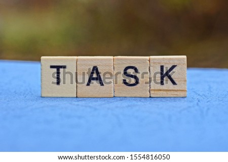 word task made of brown wooden letters on a blue table